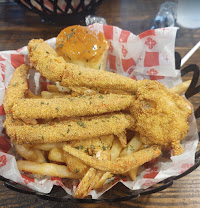Basket of golden fried catfish strips with fries